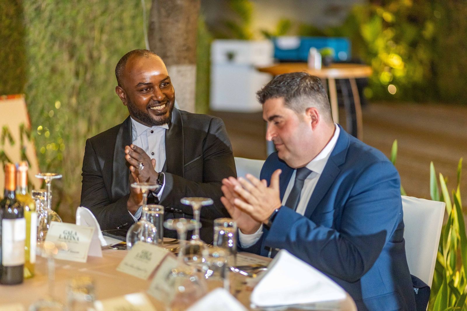 Two guests applauding at their table
