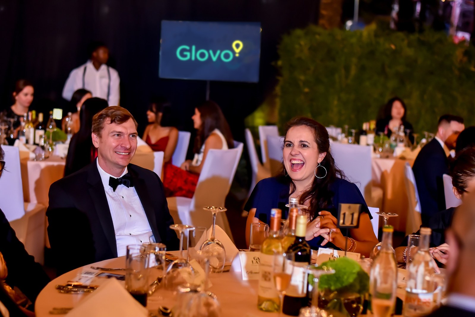 Guests in black tie laughing at their table
