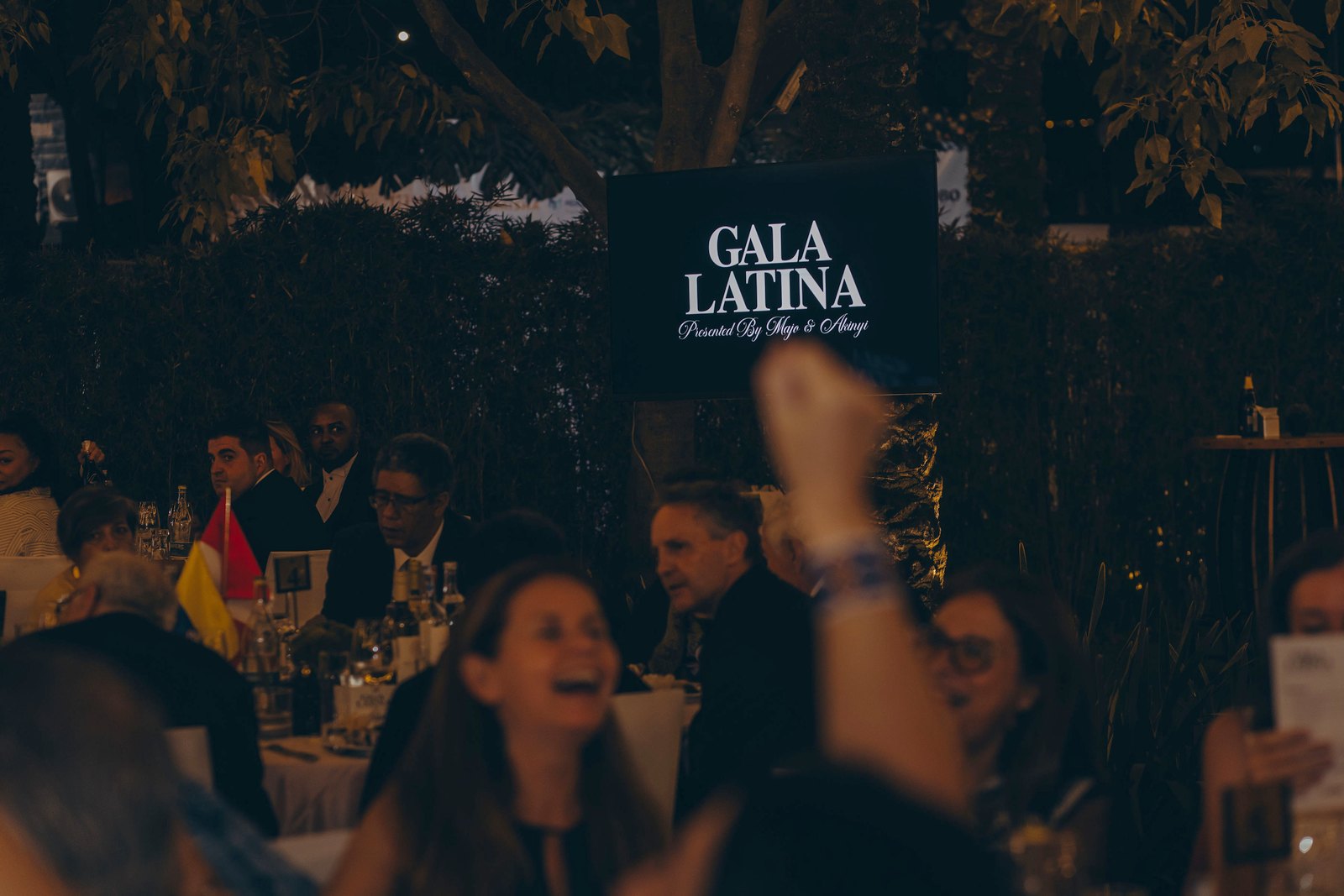 Guests at their tables beneath the Gala Latina sign